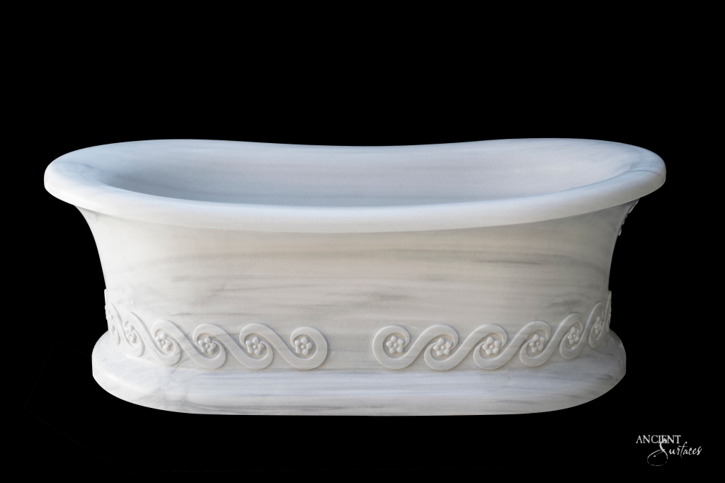 Engraved Limestone Bathtub by Ancient Surfaces, offering historical depth and classical elegance with intricate carvings inspired by Greek bathhouses and Baroque architecture.